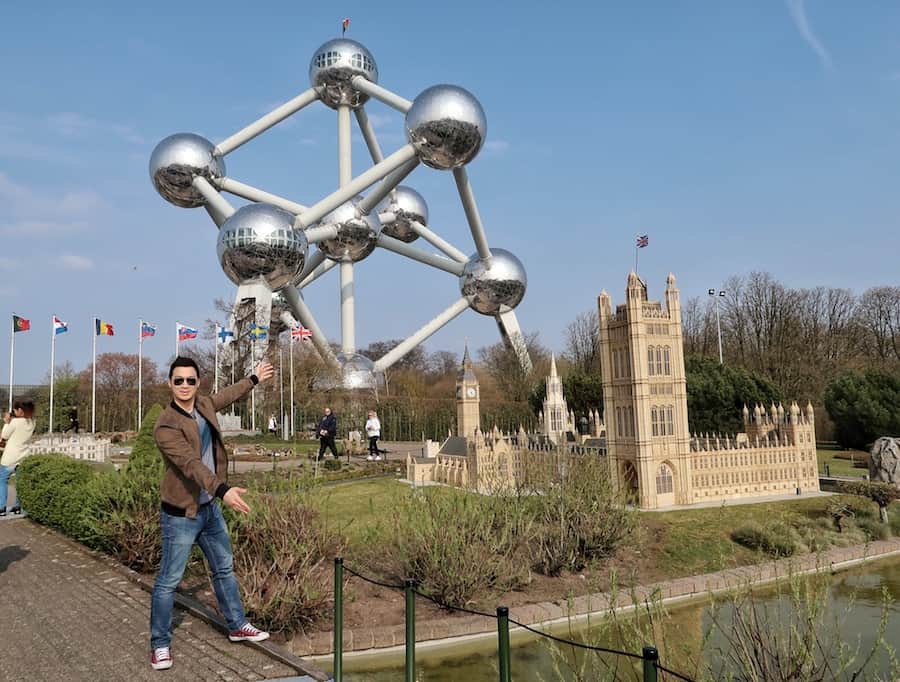 Jeff standing next to a miniature building of the Houses of Parliament. Atomium in the background