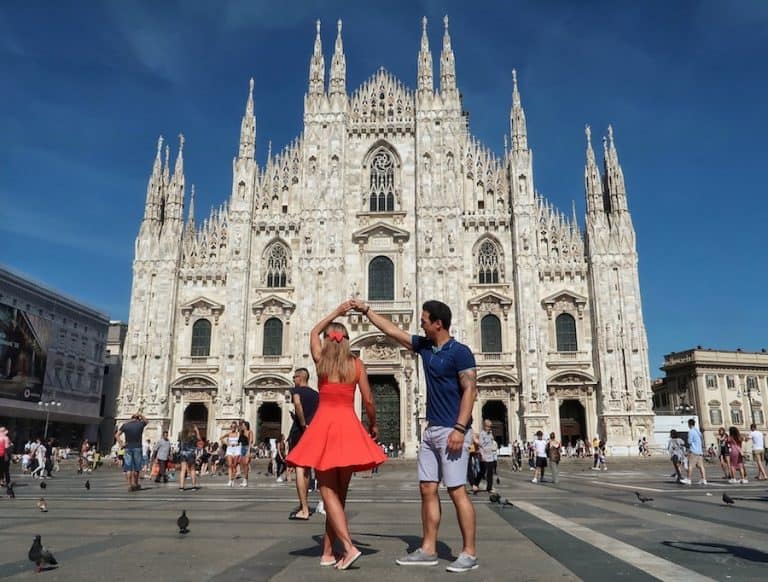 Feature image for One Day in Milan post. Jeff is spinning Zuzi in a dance with the Milan Duomo, a big cathedral, in the backdrop
