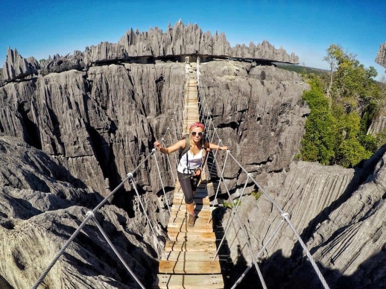 Feature image for Tsingy Guide Madagascar. Image shows Zuzi on a rope bridge with the background of sharp limestone rocks