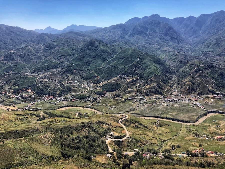 green rice terraces in front of towering mountains