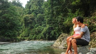 Jeff and Zuzi sitting by the edge of the river in Bukit Lawang, Sumatra