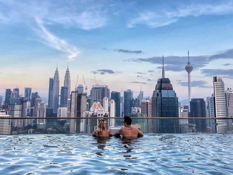 Jeff and Zuzi are in a swimming pool overlooking the city of Kuala Lumpur. Cover image for The Best Things To Do In Kuala Lumpur