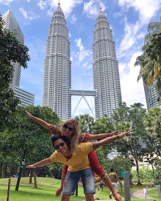 Jeff and Zuzi pretend to fly in front of the Petronas Towers