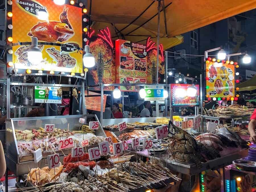 Food vendor stalls at Jalan Alor displaying a wide variety of seafood on ice with prices