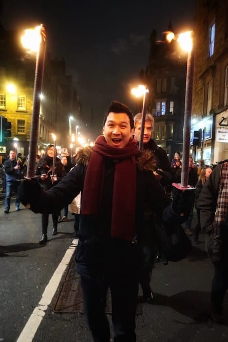 Jeff is carrying two torchlights at the Torchlight Procession in Edinburgh
