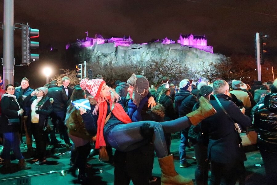 Feature image for A Short Guide To Hogmanay. Jeff holding Zuzi at the Princess Street party in Edinburgh