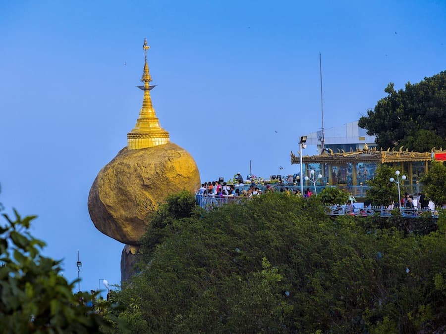 Image of the Golden Rock in Myanmar where a religious gold boulder is perched on a cliffside
