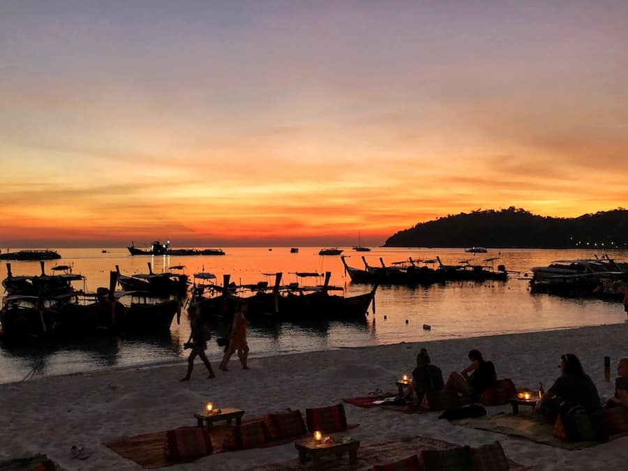Image of a beach in Thailand during sunset where the sky is a fiery red