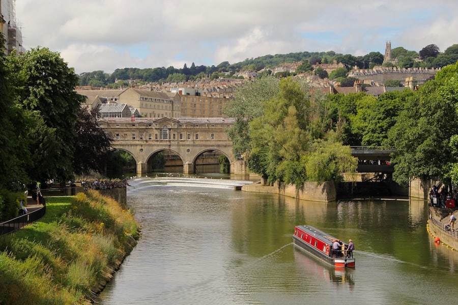 Image of a river in Bath, UK and a boat in the foreground with the city in the background.