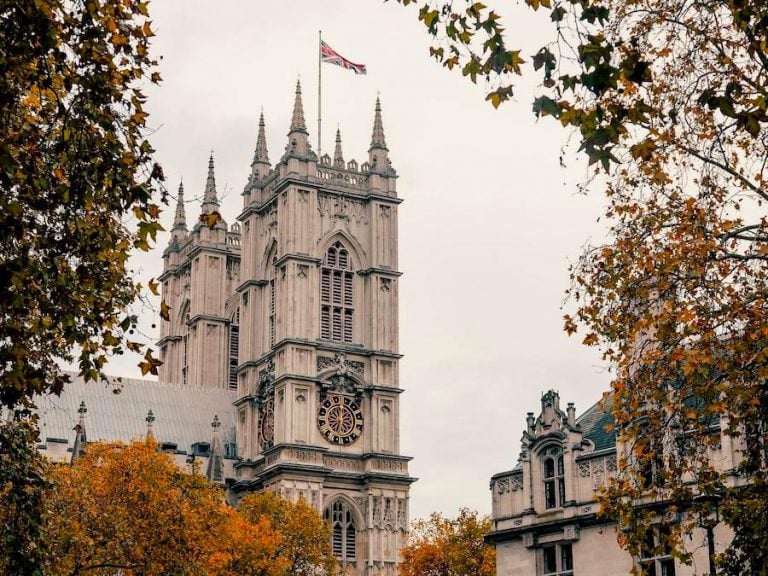 Cover image for Most Beautiful Cities In The UK post showing a church with the Union Jack flag on top