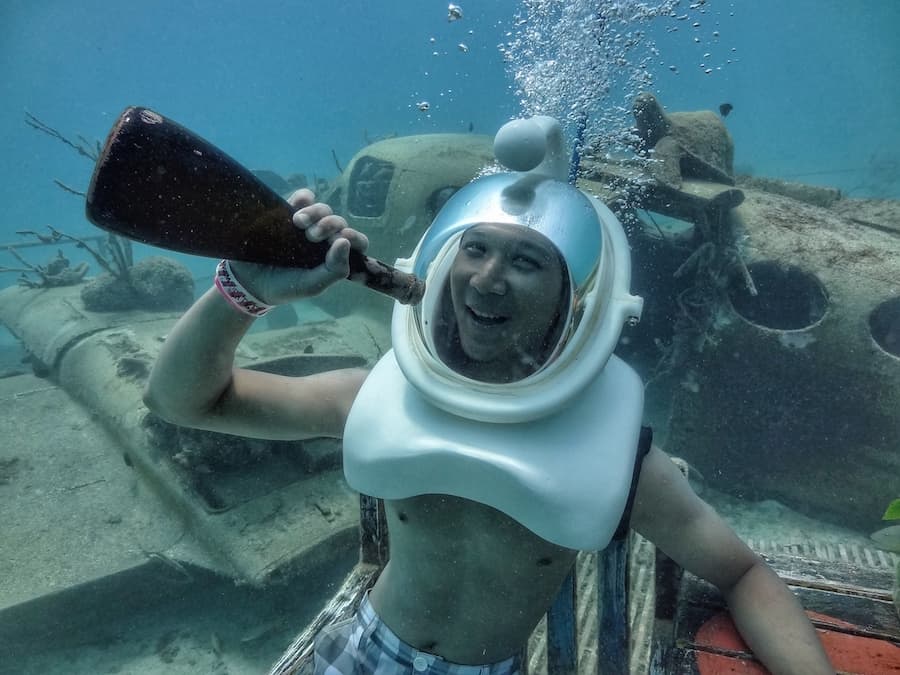 Jeff is pretending to drink a bottle under water whilewearing a special sea trek helmet