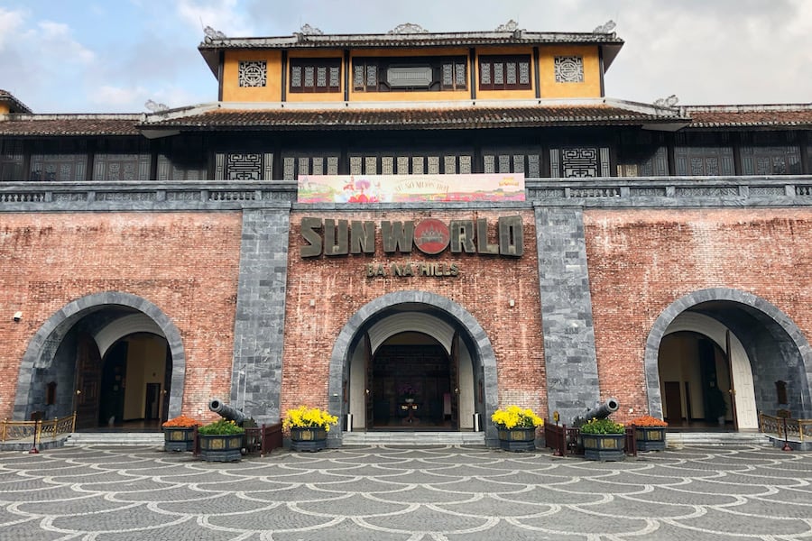 Image of the entrance to Ba Na Hills Resort in Vietnam, looking like an old brick temple or fort with Sun World written across the top