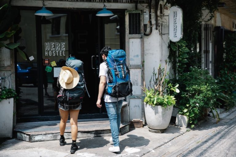 Two backpacker entering a hostel doorway - are hostels safe?
