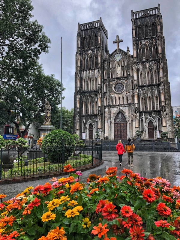 Image of St. Joseph's Cathedral, Hanoi. An old Gothic cathedral with a couple standing in the foreground