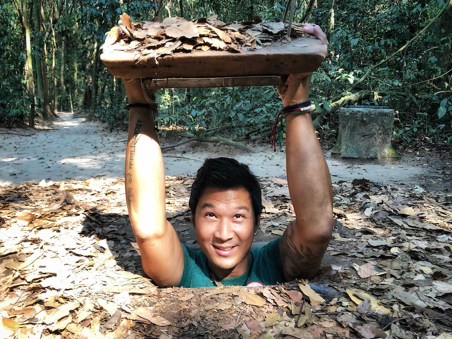 Jeff is emerging from the ground in what was a tunnel found in Vietnam. The lid is covered in leaves