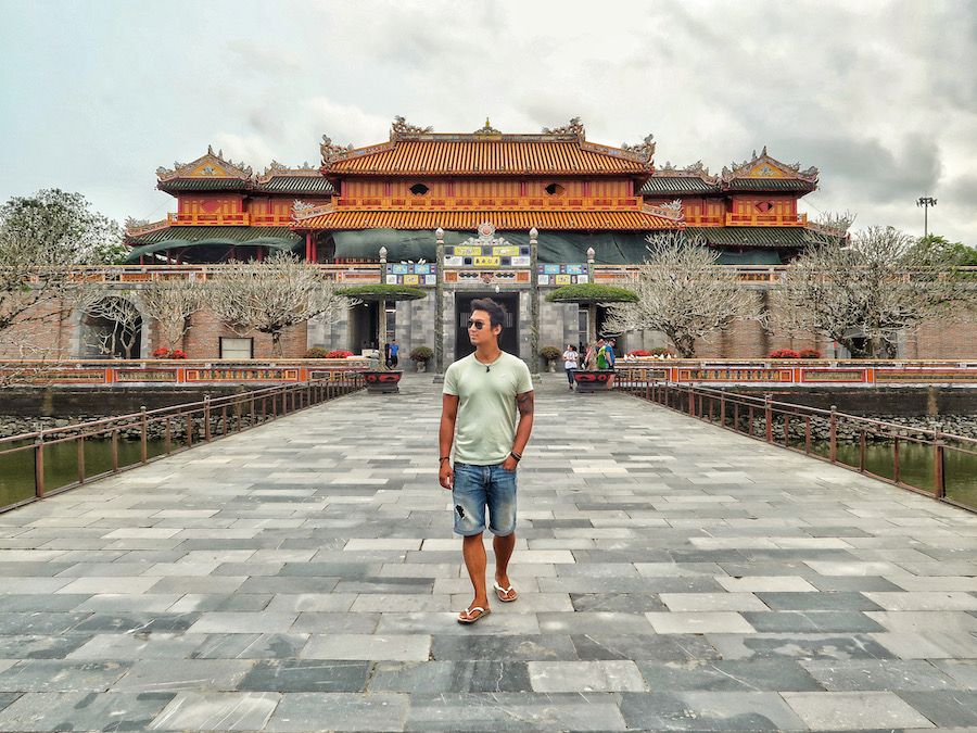 Jeff walks along a bridge with a Vietnam fort in the background