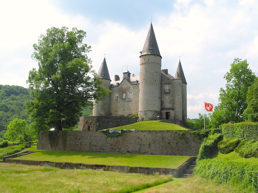 Image of Château de Vêves - a small grey castle near Dinant, perched on a little green hill