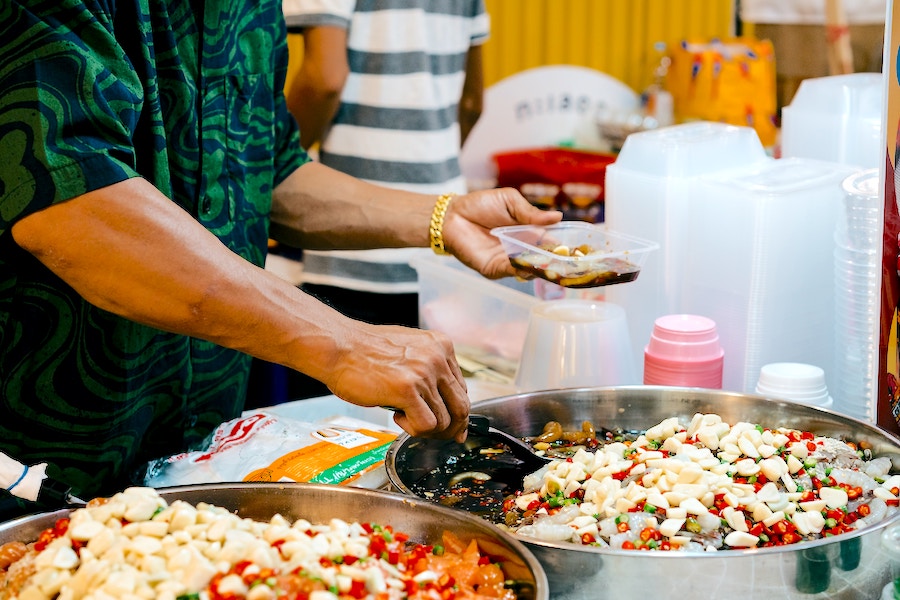 man is collecting ingredients for food from various pots