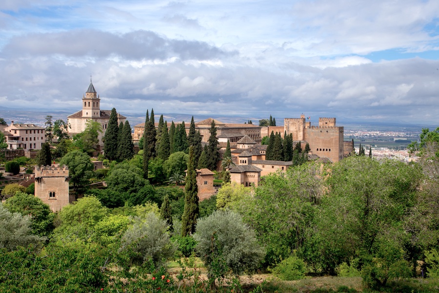 The Alhambra fortress in Granada - an Islamic fort/palace surrounded by green trees