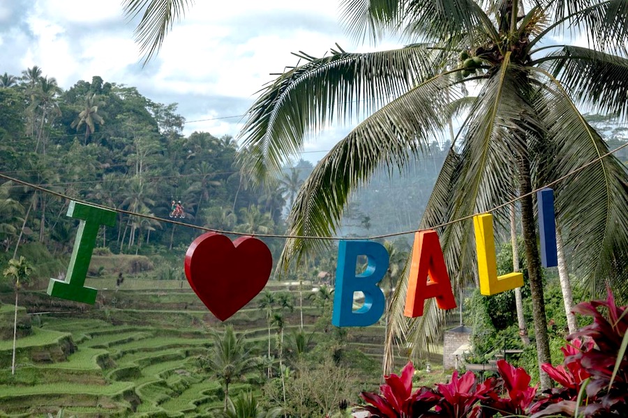 Colourful I heart Bali sign with green rice terraces in the bakground 