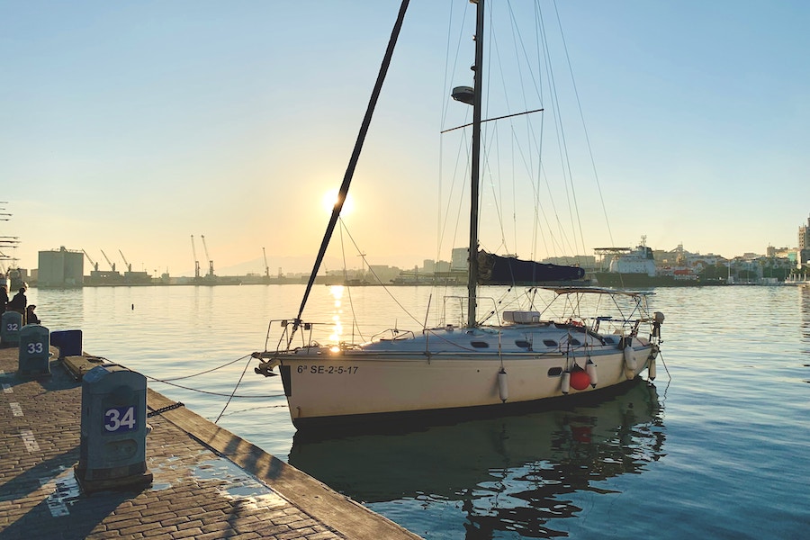 A sailing boat at Malaga harbour during sunset