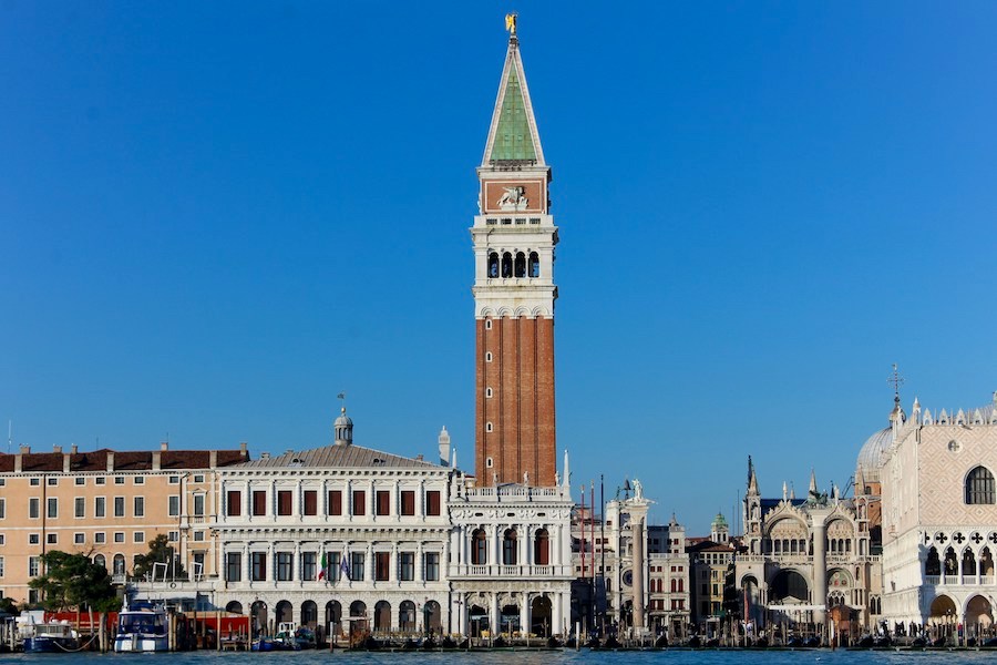 The orange brick tower of the Campanile di San Marco along the canal of Venice