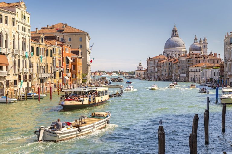 Venice In April showing a wide canal with boats and the basilica in the background.