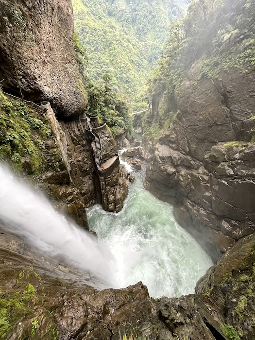 Water crashing into gorge at Pailón del Diablo with narrow cliffside path.