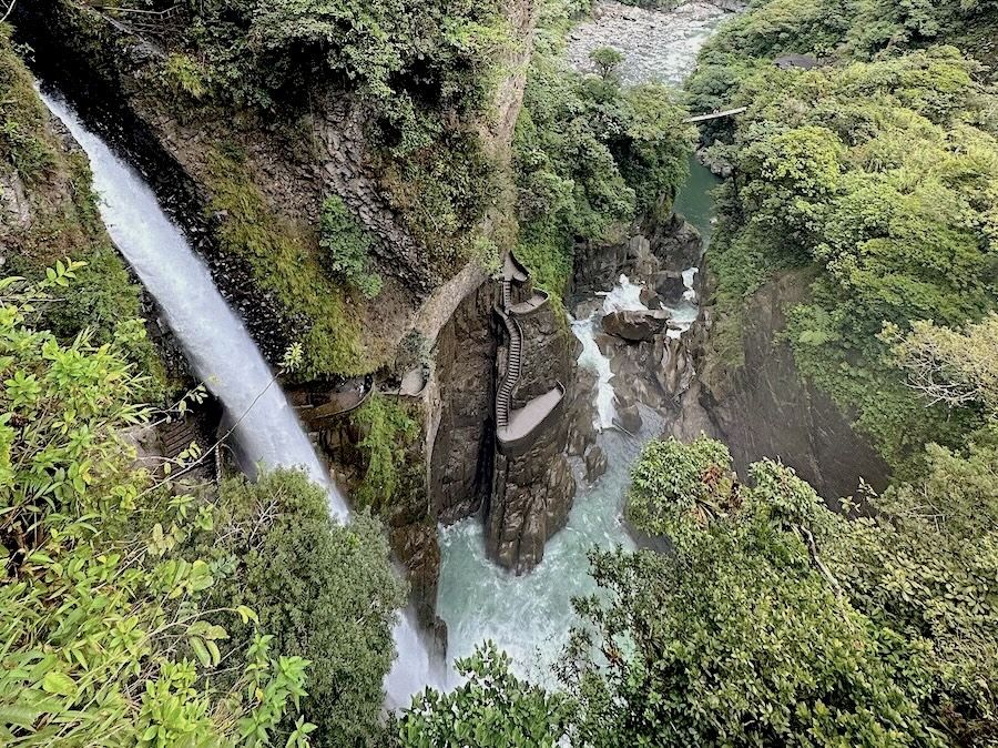 Pailón del Diablo waterfall with stone stairway in Ecuador’s rainforest canyon.