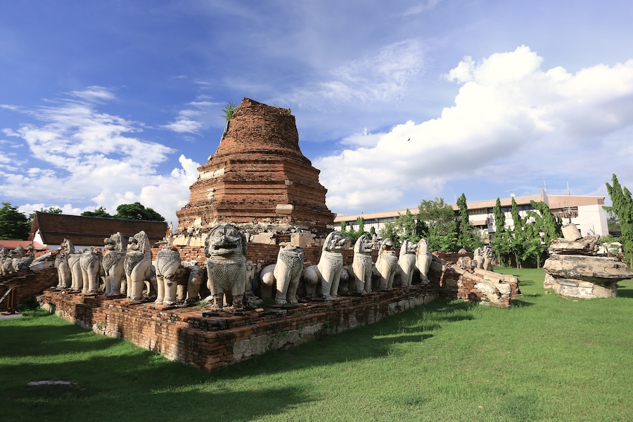 Ancient lion statues surrounding the brick chedi at Wat Thammikarat, one of the lesser-known ruins worth visiting on a trip to Ayutthaya from Bangkok