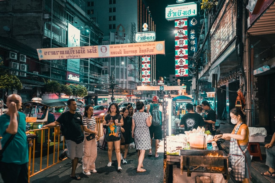 Street food stalls and people in Chinatown at night in Bangkok