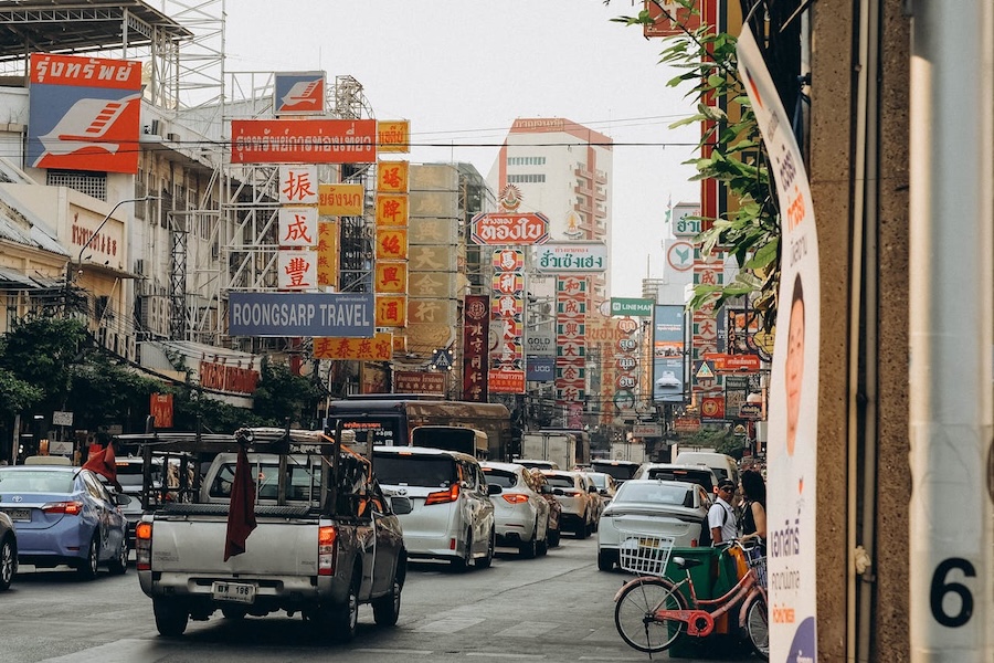 Street scene in Bangkok Chinatown with traffic and shop signs