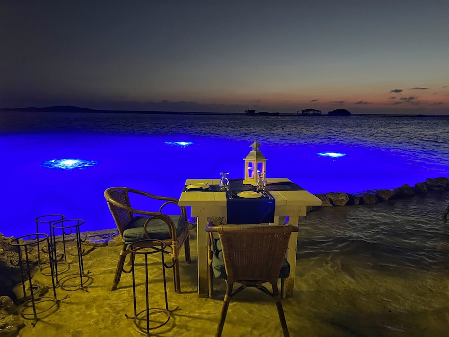 Illuminated water tables at Flying Fishbone restaurant after sunset