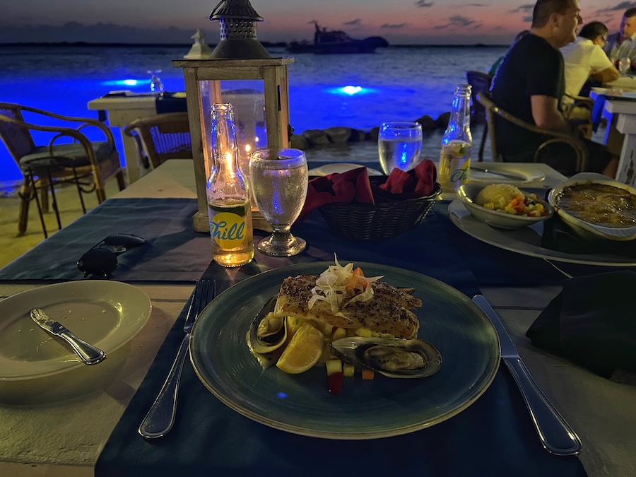 Seafood main course served beside the illuminated water at Flying Fishbone