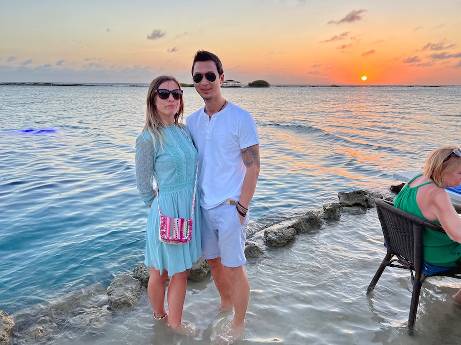 Couple standing in the water during sunset at Flying Fishbone restaurant